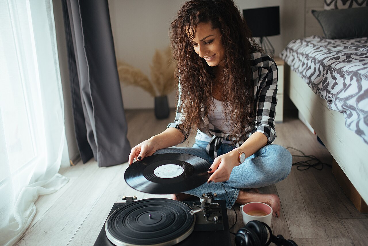 Someone relaxing in a cozy room while records play on a turntable.