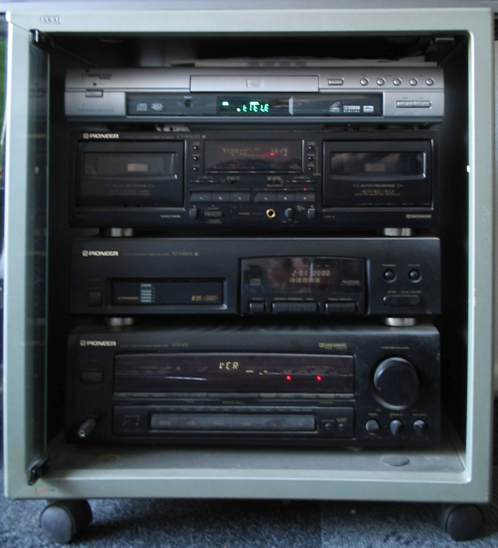A Hi-Fi system built from separates: receiver, CD player and cassette deck stacked on a rack.